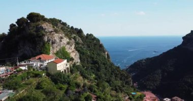 The remote settlement aerial view with rugged mountains. Rural terrace farming on a hilly landscape, drone footage. Aerial view of mountains nearby the Ocean. Positano landscape. Italy, Amalfi Coast.