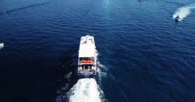 Turquoise blue water sea with yacht sail with sunset. Aerial top down view of a boat on a mediterranean sea. One ship boat in beautiful nature ocean landscape. Motor boat moving over the deep blue sea