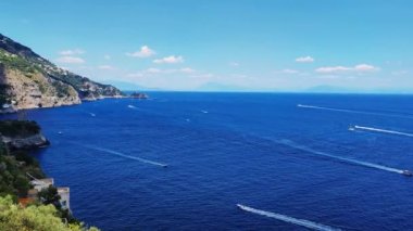 Akdeniz 'de rüzgar dalgaları içinde yelken açmak. Güneşli bir yaz günü, mutlu ve heyecanlı insanlar yelkenli ve yatta. Sakin su manzarası ve ulaşım. Koyu mavi bir denizde, beyaz denizlerde yelkenli.