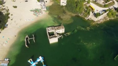 Village flooded and submerged underwater. Abandoned Rummu quarry, turquoise lake with underwater prison in the middle. Underwater city, at the bottom of lake. Old stone stairs under water. 