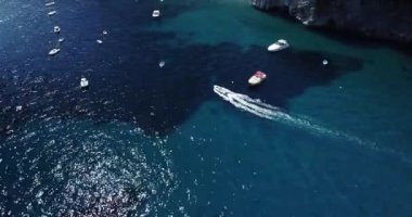 Turquoise blue water sea with yacht sail with sunset. Aerial top down view of a boat on a mediterranean sea. One ship boat in beautiful nature ocean landscape. Motor boat moving over the deep blue sea