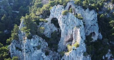 Arco Naturale, limestone arch that forms a bridge between two pillars of rock. Unique rock formation. Travel destination, Capri island, Italy. Blue water. Natural limestone arch. High quality.