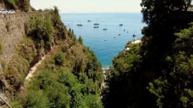 Positano, tourist destination on the Amalfi Coast. Aerial Drone View of Positano near Naples, Italy. Famous Mediterranean resort turquoise sea Blue Ocean with boats. Positano village at sunset lights.