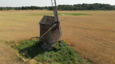 Antika ahşap yel değirmeni. Kırsalda eski bir yel değirmeni. Alternatif enerji. Rüzgar türbini hareket ediyor ve dönüyor. Çevre dostu kavram. Eko çiftliği, yeşil ekolojik dünya, çiftçilerde rüzgar çiftliği.