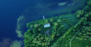 Kırsal bir köyü olan havadan manzaralı bir ev, göl kenarında sarı yapraklı bir sonbahar ormanı. Ormanın içindeki kulübe. Güzel bir varış yeri. İnsanlar bir evden diğerine yürüyor..