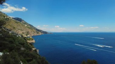 İtalya 'nın Napoli kıyısındaki Amalfi' nin Tyrrhenian deniz kıyısının insansız hava aracı görüntüsü. Lüks bir yat derin mavi okyanus denizinde yüzüyor. Akdeniz, güzel hava manzarası yatlar, botlar, dağlar.