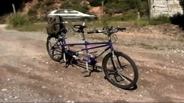 手でVhsヴィンテージフィルム レトロな振動 2人の自転車 旅行の休日のためのタンデム 晴れた夏の日に自転車に乗っている二人 レトロVhs映像 ヴィンテージVhs Cからスキャンします — ストック動画