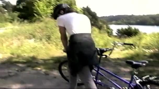手持Vhs Vintage Film 复古氛围 两人轮流骑自行车 旅游度假 两个人在阳光灿烂的夏日骑自行车 旧版Vhs C的翻看Vhs镜头 — 图库视频影像