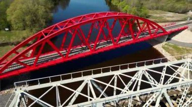 Tren köprüsünün üzerinden hava görüntüsü. Harika bir sinematik çekim. Gün doğumunda büyük bir nehrin üzerindeki demiryolu köprüsü. Estonya 'da tren köprüsü. Yüksek kalite 4k görüntü
