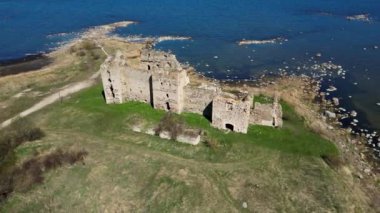 Estonya 'da manzaralı kırsal alanda bir kale. Güzel taşlar ve resifler. Kuzey 'in güzel tarihi kalıntıları, deniz kenarları, okyanus. Ot Tepesi 'ne tünemiş Taş Kale ve Okyanus kıyısındaki Uçurum Kuleleri