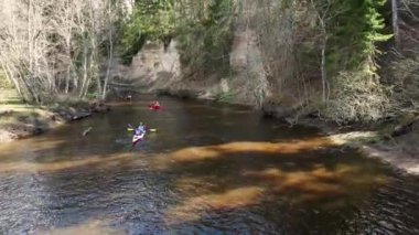 İnsansız hava aracı, nehir boyunca giden bir grup kadın ve erkeğin sürdüğü bir spor kanosuna ateş açtı. Kano üzerinde açık hava aktiviteleri, su sporları. Her yere git. Aile sporları. Yaz. Takım tarafından işletilen spor kanosu.