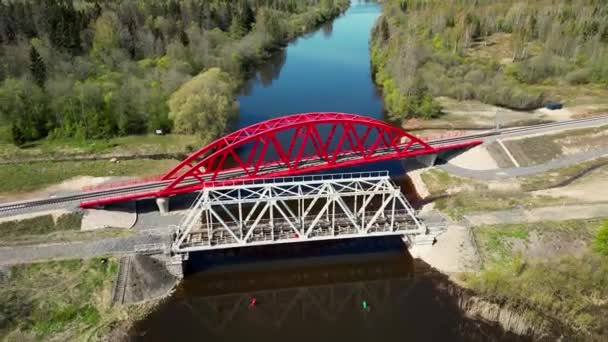 鉄道橋の上の空中ビュー 素晴らしい映画撮影 朝の日の出に大きな川の上に鉄道橋 エストニアの鉄道橋 高品質4K映像 — ストック動画