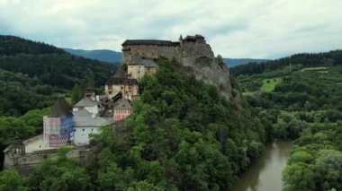 Slovakya 'daki Orava kalesinin hava görüntüsü. Ortaçağ kalesi son derece yüksek ve dik bir tepede. Orava Nehri yakınlarındaki yüksek ve dik uçurumlardaki Ortaçağ Oravsky Hrad kalesi. Hava 4K .