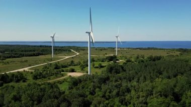 Yel değirmeni parkı yeşil enerjisi İHA görüşü, yel değirmeni rüzgar çiftliği. Büyük pervane rüzgar jeneratörü. Modern yenilenebilir yakıt teknolojileri okyanusun yanında. Yel değirmeni türbinleri yenilenebilir enerji üretiyor.