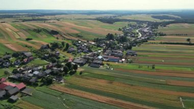 Polonya 'da evleri ve tarlaları olan güzel bir köy. Çeşitli yeşil alanların dekoratif süslemelerinin havadan görünüşü. Suloszowa, Polonya. Evleri ve tarlaları olan güzel bir köy. Tarladaki köy. 