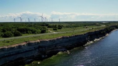 Yel değirmeni parkı yeşil enerjisi İHA görüşü, yel değirmeni rüzgar çiftliği. Büyük pervane rüzgar jeneratörü. Modern yenilenebilir yakıt teknolojileri okyanusun yanında. Yel değirmeni türbinleri yenilenebilir enerji üretiyor.