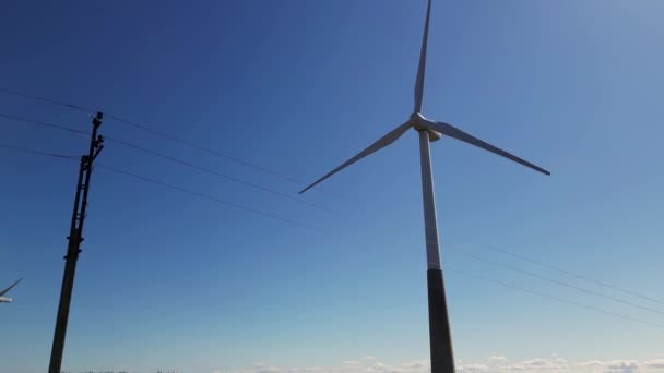 有叶片的大型风力涡轮机 在蓝天的野外鸟瞰中 从空中俯瞰风车农场 以促进能源生产 产生清洁可再生能源可持续发展的风力涡轮机 — 图库视频影像