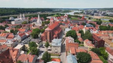 Kaunas şehrinin güzel ufuk çizgisi kilise kuleleri ve Nemunas nehrinin yanında belediye binası olan eski bir kasaba. Kaunas 'ın Kaunas Katedrali manzaralı eski kasabası, belediye binası. Kırmızı çatıların havadan görünüşü.