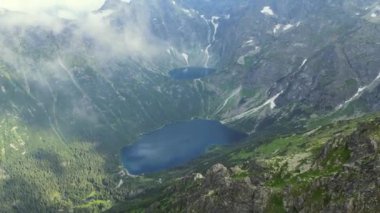 Bir kuş gibi bulutların üzerinde süzülüyorsun. Dolomitler, İtalya 'daki dağların üzerinden insansız hava aracı görüntüsü. Polonya 'daki güzel dağ ve sis manzaralı bulutların hava görüntüleri, Morskie Oko. Ünlü turizm beldesi.