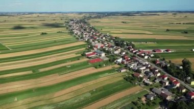 Polonya 'da evleri ve tarlaları olan güzel bir köy. Çeşitli yeşil alanların dekoratif süslemelerinin havadan görünüşü. Suloszowa, Polonya. Evleri ve tarlaları olan güzel bir köy. Tarladaki köy. 