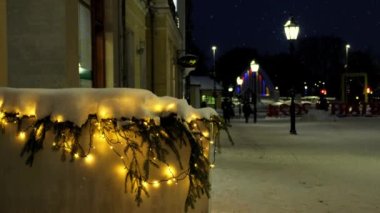 Sessiz ve rahat bir kasabada Noel arifesi, beyaz kar taneleri fırıl fırıl döner ve şehrin sokaklarına düşer. Kar yağarken sakin bir kış gecesi. Tatil ışıklarıyla aydınlatılmış Noel Avrupa şehri. Tartu, Estonya.