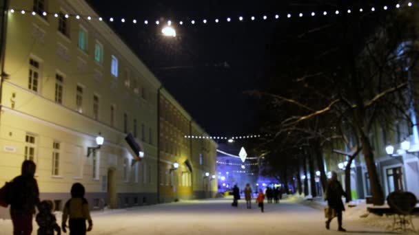 静かな居心地の良い町でクリスマスイブ ホワイトスノーフレークが渦巻き 街路に落ちます 人々は通りを歩いている 雪が降る冬の寒い夜 クリスマスの街の休日のライト エストニア トゥンタ — ストック動画