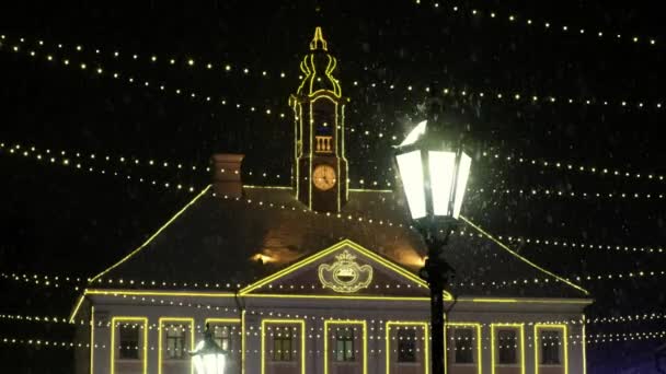 第一场降雪街上的灯笼旁边飘着雪 舒适的冬夜 背景着冬夜的灯光 冬季有雪的市场 耶诞节欧洲城市灯火通明 — 图库视频影像