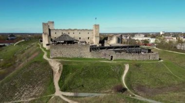 Estonya 'da kırsal alanda Estonya bayrağı dalgalanırken bir kale. Taşlar. Yüksek kalite 4k görüntü