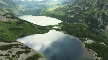 Suyun üzerinde yüksek uçmak ve dağların üzerinde gün doğumunda sis denizi. Tatra Dağları 'ndaki Morskie Oko Gölü. Bulutların üzerinde uçuyor. Bereketli Manzara ve İki Göllü Muhteşem Dağ Sırası