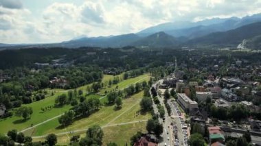 Hava manzaralı resimli dağ köyü. Polonya 'daki Tatra Dağları' nın altındaki Zakopane kasabasının hava manzarası. Zakopane tatil köyü ve yüksek Tatra dağları. Yeşil çam ormanı, tepelerdeki yazlık oteller.