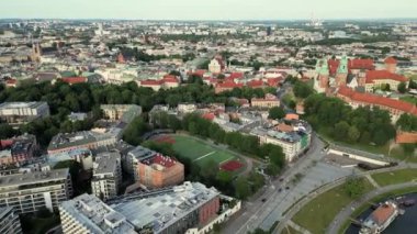 Krakow, Polonya. Wawel kraliyet kalesi ve katedrali, Vistula nehri, park ve gezinti alanında yürüyen insanlar. Krakow, Polonya, Eski Şehir 'in hava görüntüsü. Arka planda yavaş hareket eden dönme dolap. 