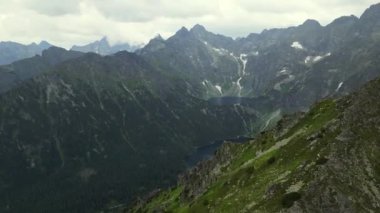 Suyun üzerinde yüksek uçmak ve dağların üzerinde gün doğumunda sis denizi. Tatra Dağları 'ndaki Morskie Oko Gölü. Bulutların üzerinde uçuyor. Bereketli Manzara ve İki Göllü Muhteşem Dağ Sırası.