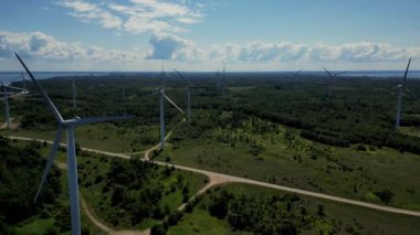 Yel değirmenleri ve güneş enerjisi santrali yenilenebilir enerjiyi canlı bir günbatımı arka planına karşı kullanıyorlar. Aksiyon halindeki yeşil teknolojinin çarpıcı bir tasviri alacakaranlıkta alternatif enerjinin özünü yakalıyor..