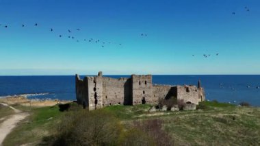 Estonya 'da manzaralı kırsal alanda bir kale. Güzel taşlar ve resifler. Kuzey 'in güzel tarihi kalıntıları, deniz kenarları, okyanus. Ot Tepesi 'ne tünemiş Taş Kale ve Okyanus kıyısındaki Uçurum Kuleleri