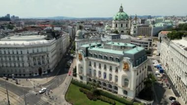 İnsanlar yürüyor ve Viyana caddesinde arabalar sürüyor. Avusturya 'nın başkenti Viyana' nın eski ana caddesinde birçok dükkan ve restoran bulunmaktadır. Heldenplatz, Rathaus, Volksgarden ve Viyana Üniversitesi ufuk çizgisi