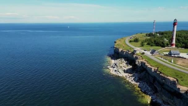 爱沙尼亚海岸有一个陡峭的河岸 波罗的海的野生海岸 陡峭的河岸和灯塔 阳光下的白色海岸线 阳光灿烂 阳光灿烂 在海上度过的绿色夏日 高质量4K — 图库视频影像