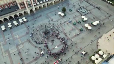Saint Mary Bazilika pazar meydanının üzerinde uçan Krakow ana pazar meydanının hava aracı görüntüsü. Polonya 'nın Krakow kentindeki Eski Kent Ana Pazar Meydanı' nı ziyaret eden turistler. Yüksek kalite 4k 
