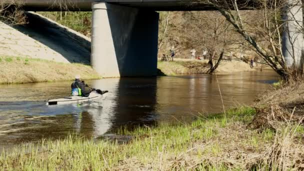ローイングスポーツの一種であるカヌーは 川を下るデュアルカヤックの後に続きます チームが運営するスポーツカヌーの空中ドローン鳥の目のビデオ 穏やかな水の上を走るチームの人々とスポーツカヌー — ストック動画