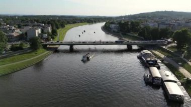 Krakow şehrinin gökyüzü manzarası, Polonya, Wawel kalesi ve Vistula nehri, Krakow, Polonya 'daki nehir manzarası. Polonya nehrinde tekne gezisi. Teknede turist var. Yüksek kalite 4k görüntü