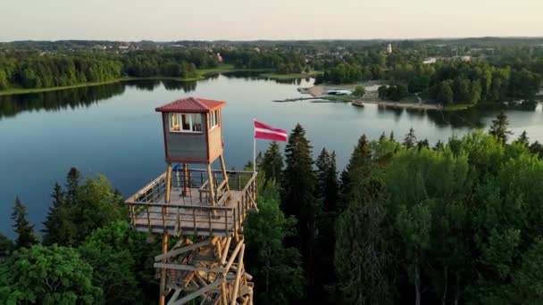 拉脱维亚的国旗非常详细 拉托维亚国旗 美丽动人的空中落日景色俯瞰着阿尔克斯纳神殿山公园的观光塔 美丽的落日色彩和背景湖水 — 图库视频影像