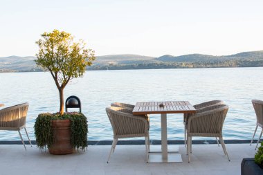 Restoran masası ve deniz kenarındaki sandalyeler. Yaz tropik tatil konsepti. Rahatlama fikri.