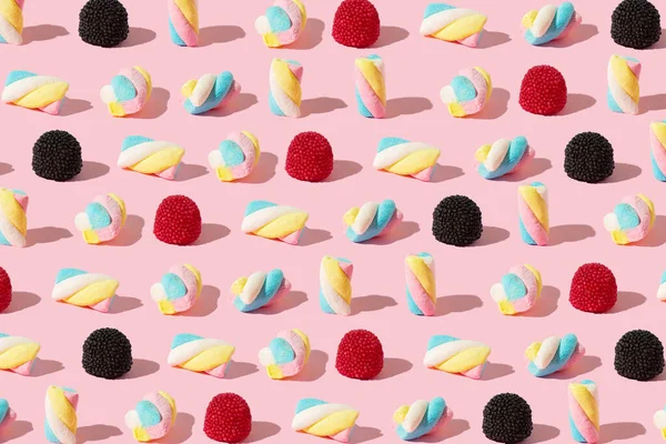 Marshmallows Und Gummibärchen Stehen Einer Reihe Mit Sonnenschatten Auf Rosa — Stockfoto