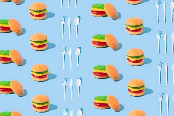 Гамбургер Форме Конфет Столовых Приборов Солнечными Тенями Синем Фоне Продовольственная — стоковое фото