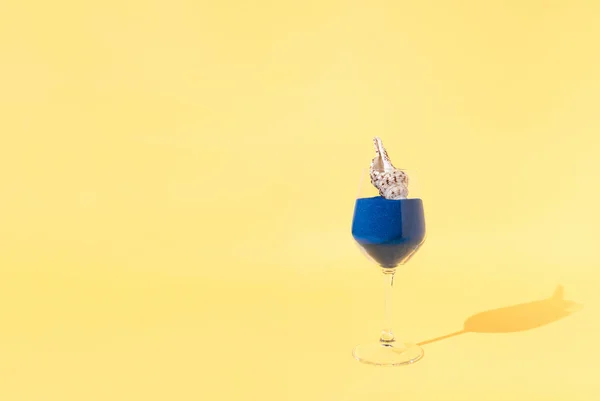 Abstrakcyjny Comopositon Wykonany Szkła Pełnego Niebieskiego Piasku Muszelką Jasnożółtym Tle — Zdjęcie stockowe