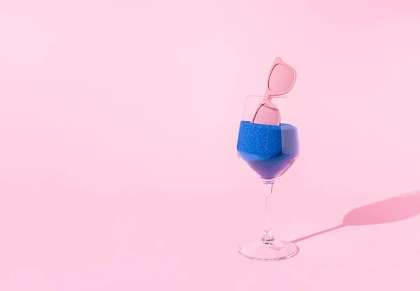 Absztrakt Kompoziton Üvegből Tele Kék Homokkal Napszemüveggel Pasztell Rózsaszín Háttérrel — Stock Fotó