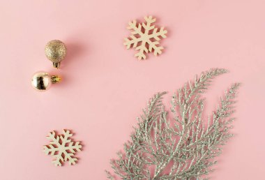 Pastel pembe arka planda Noel pembesi süslemeleri. Minimum konsept. Noel besteliği.