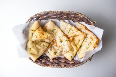 Masala Kulcha Naan, gri arka planda, bangladeş yemeklerinin üst görüntüsünde izole edilmiş bir sepette hizmet verdi.
