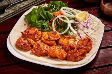 Baharatlı Sheesh Tawook ya da şiş tikka boti kebabı. Salata, limon ve ekmekle servis ediliyor.