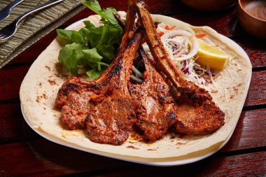 Limonlu ızgara kuzu pirzolası, salata ve ekmek.