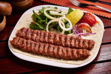 Baharatlı bbq Tandoori Lamb Kebap. Ekmek, limon ve salata ile servis ediliyor. Orta doğu yemekleri masasında servis ediliyor.